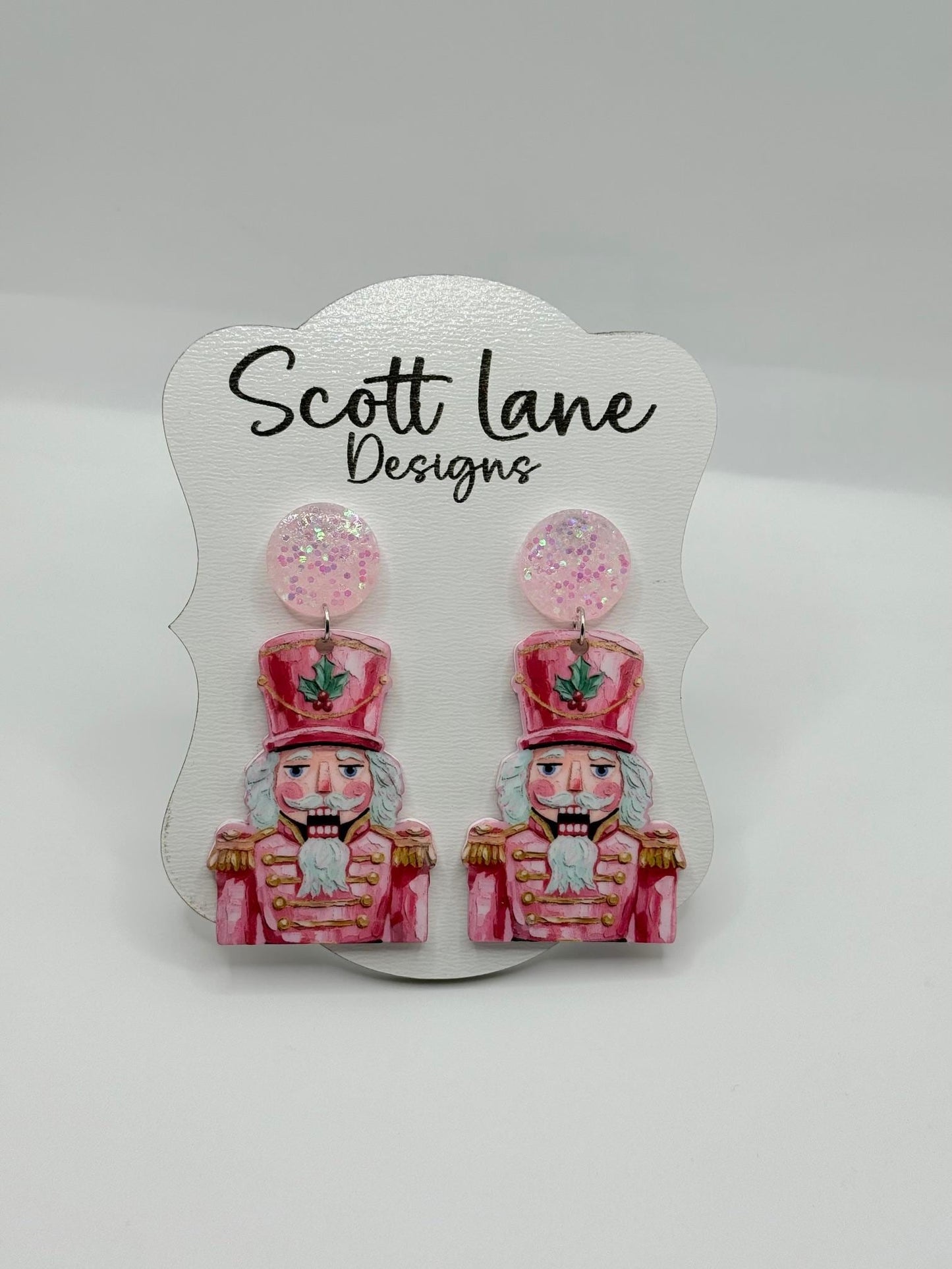 Earrings with nutcracker design on a Scott Lane Designs card.