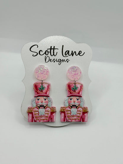 Earrings with nutcracker design on a Scott Lane Designs card.