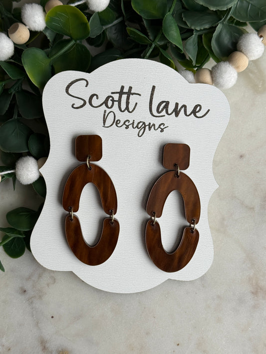 Brown hoop earrings on a Scott Lane Designs card with decorative elements.
